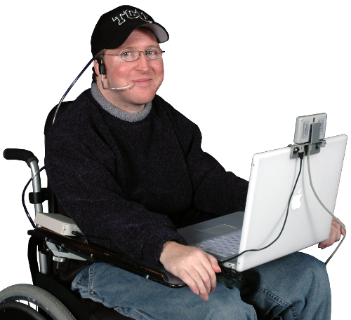Person in a wheelchair using a laptop with a headset on a white background