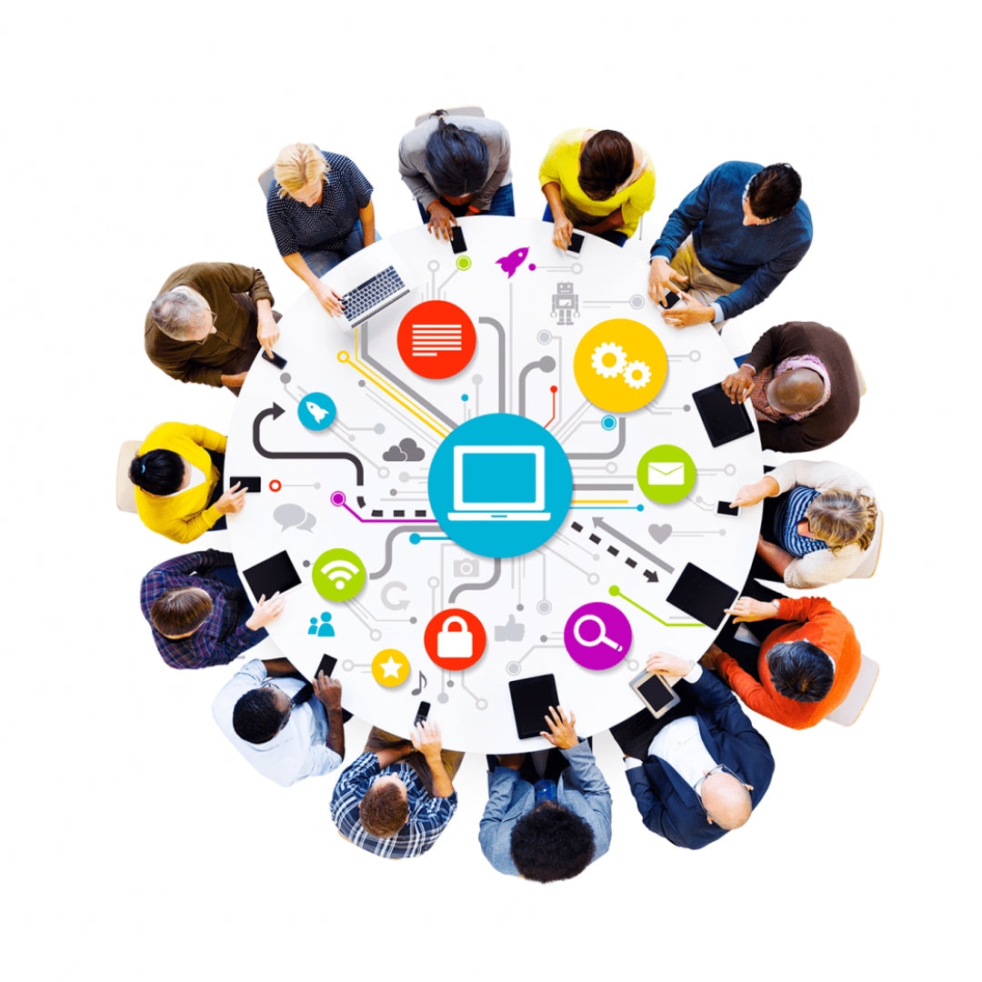 Poeple sit around a round table using a variety of different electronic devices