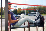 Woman listening to Victor Reader Stream through headphones at a bus stop